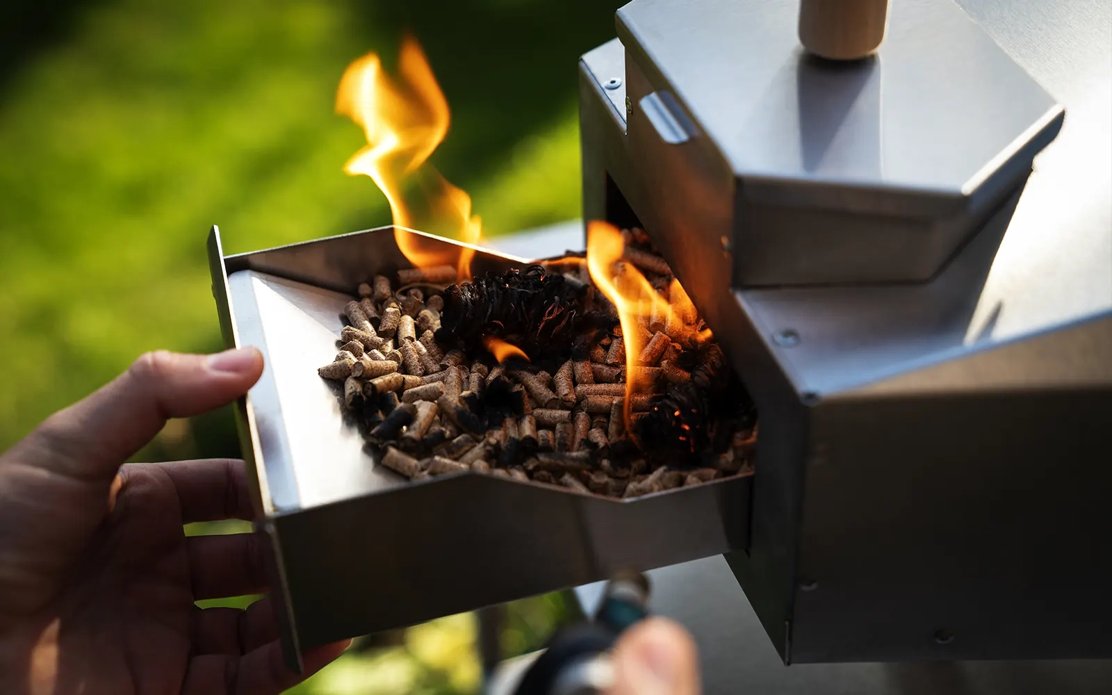 Close-up of pellets being lit in the hopper of a pizza oven