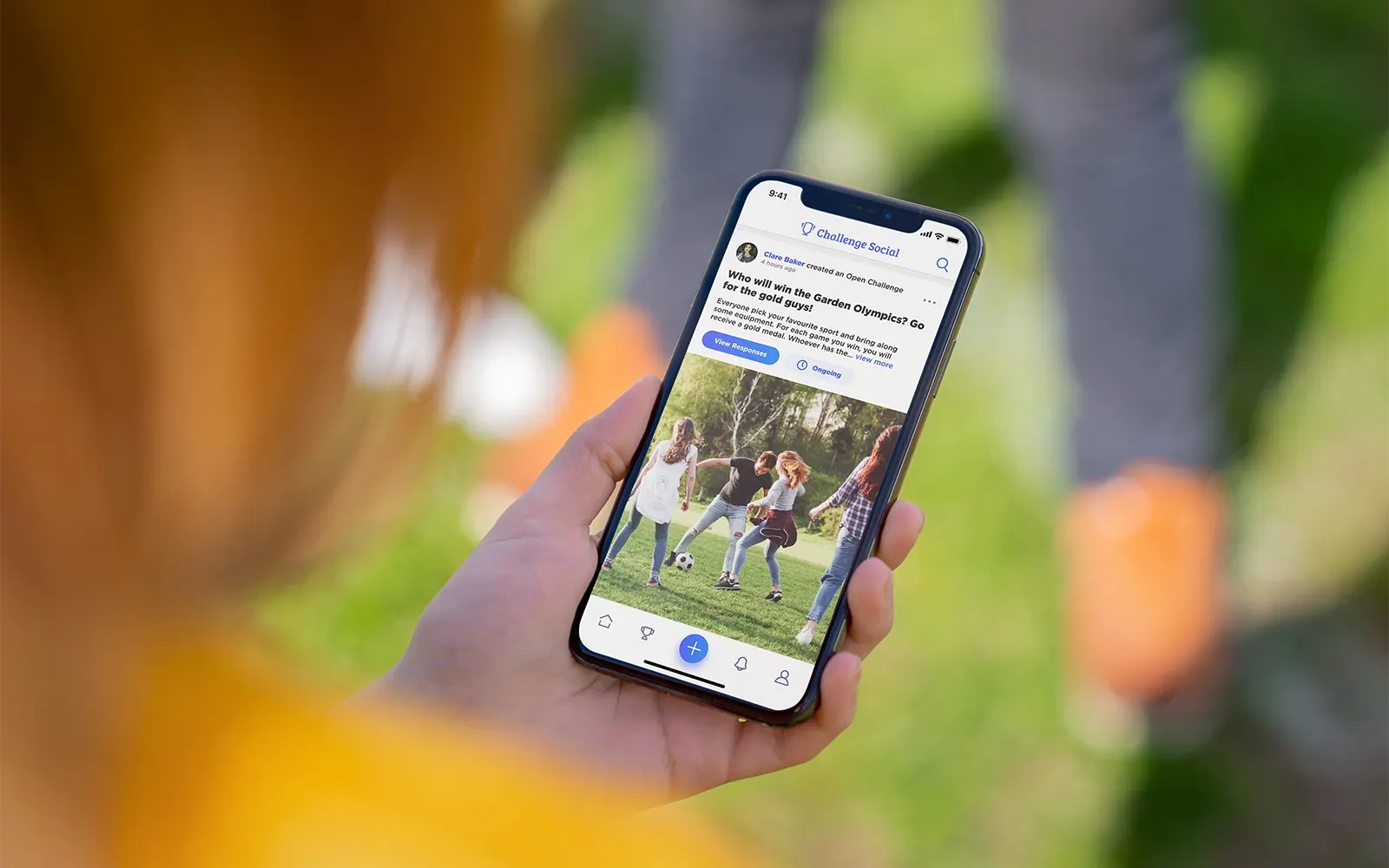 A close up of a smart phone showing the newsfeed page from the Challenge Social app