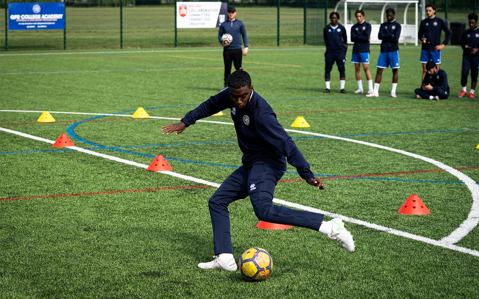 An action shot of a teenage boy during a football training session at a football pitch