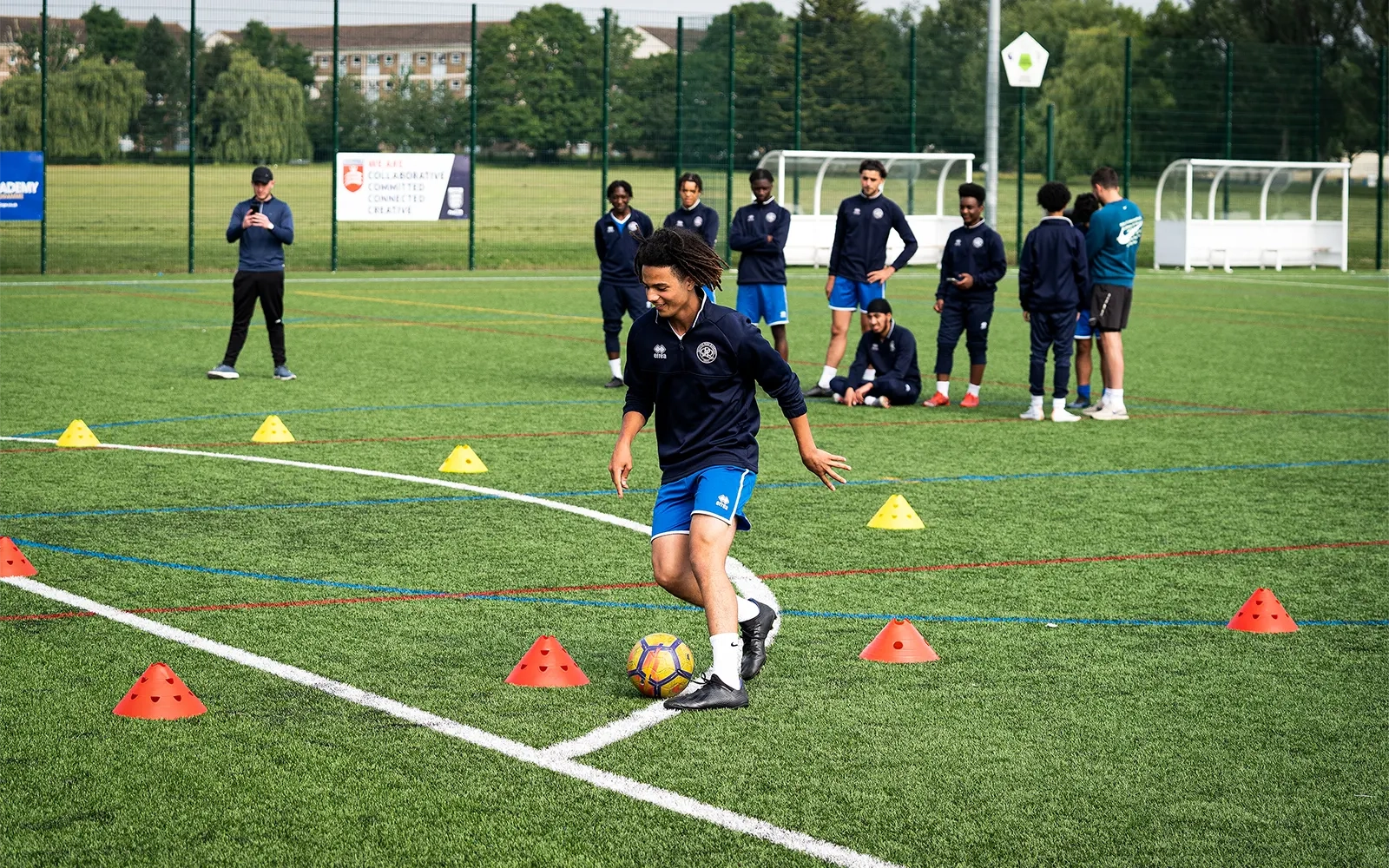 An action shot of a teenage boy during a football training session at a football pitch