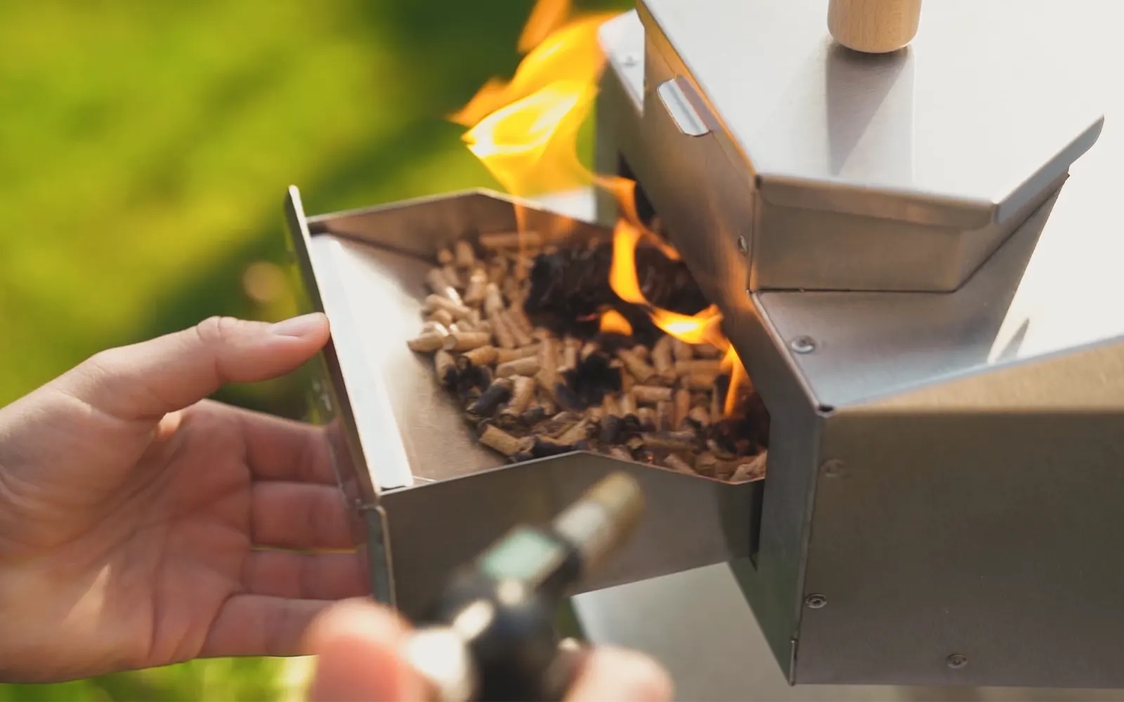 A close-up of a pizza oven being lit in a garden