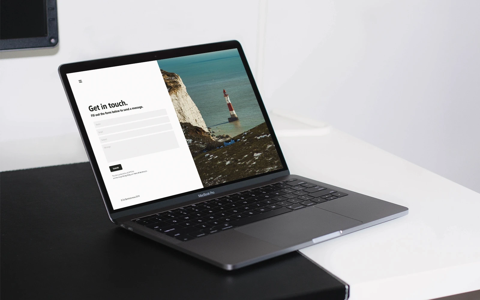 A laptop in a clean and modern room on a displaying the contact page of the Ed Bartholomew website