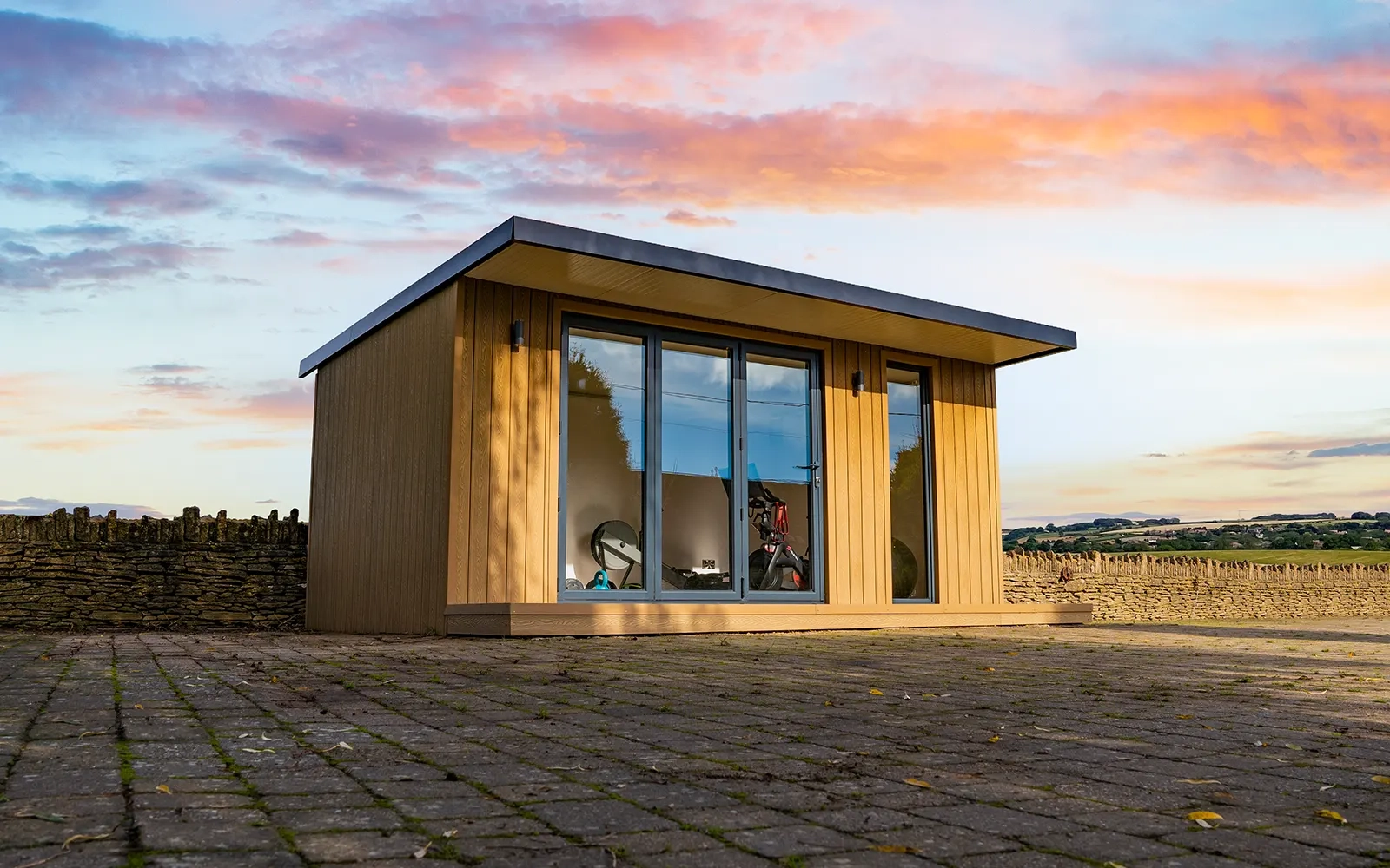 A Nexus Garden Room half lit up by the sun with a beautiful sunrise in the background