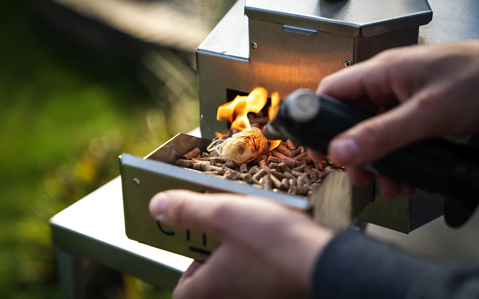 Close-up of pellets being lit in the hopper of a pizza oven