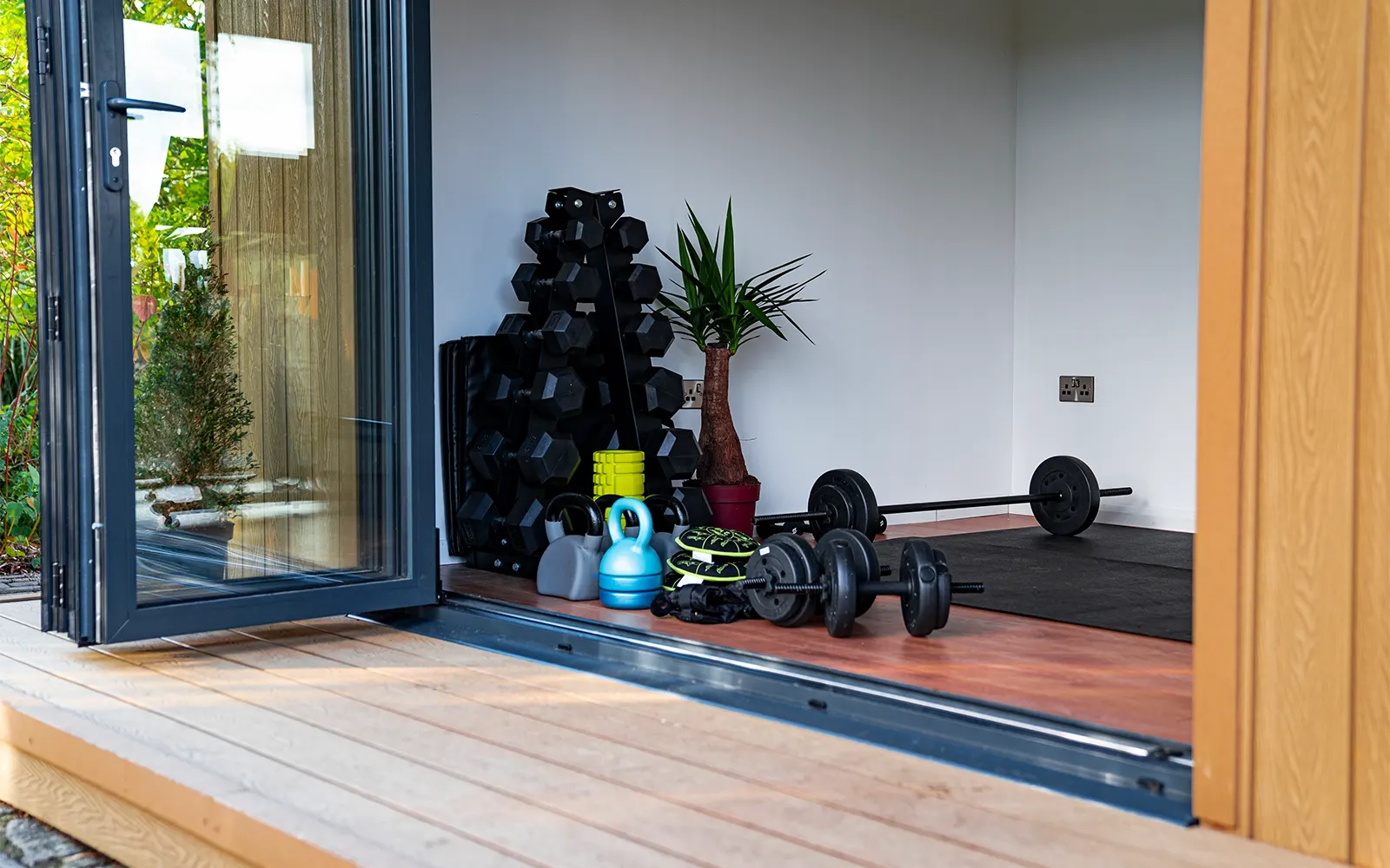 A photo looking into a garden room which has been set up as a home gym