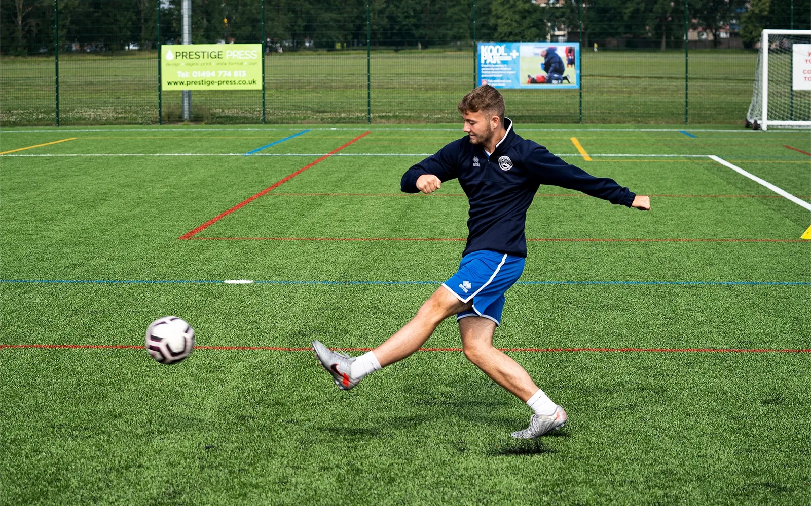 An action shot of a teenage boy during a football training session at a football pitch