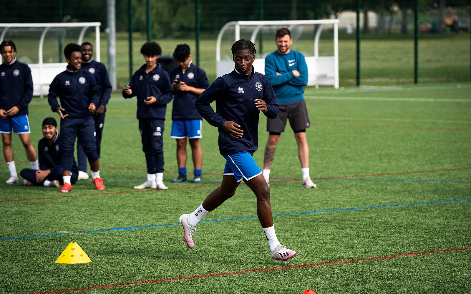 An action shot of a teenage boy during a football training session at a football pitch