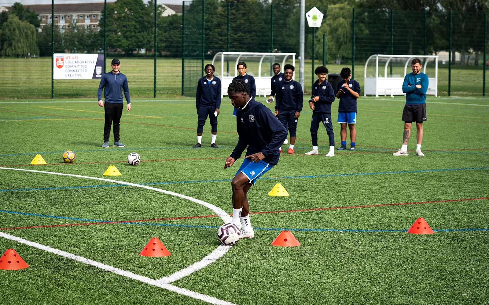 An action shot of a teenage boy during a football training session at a football pitch