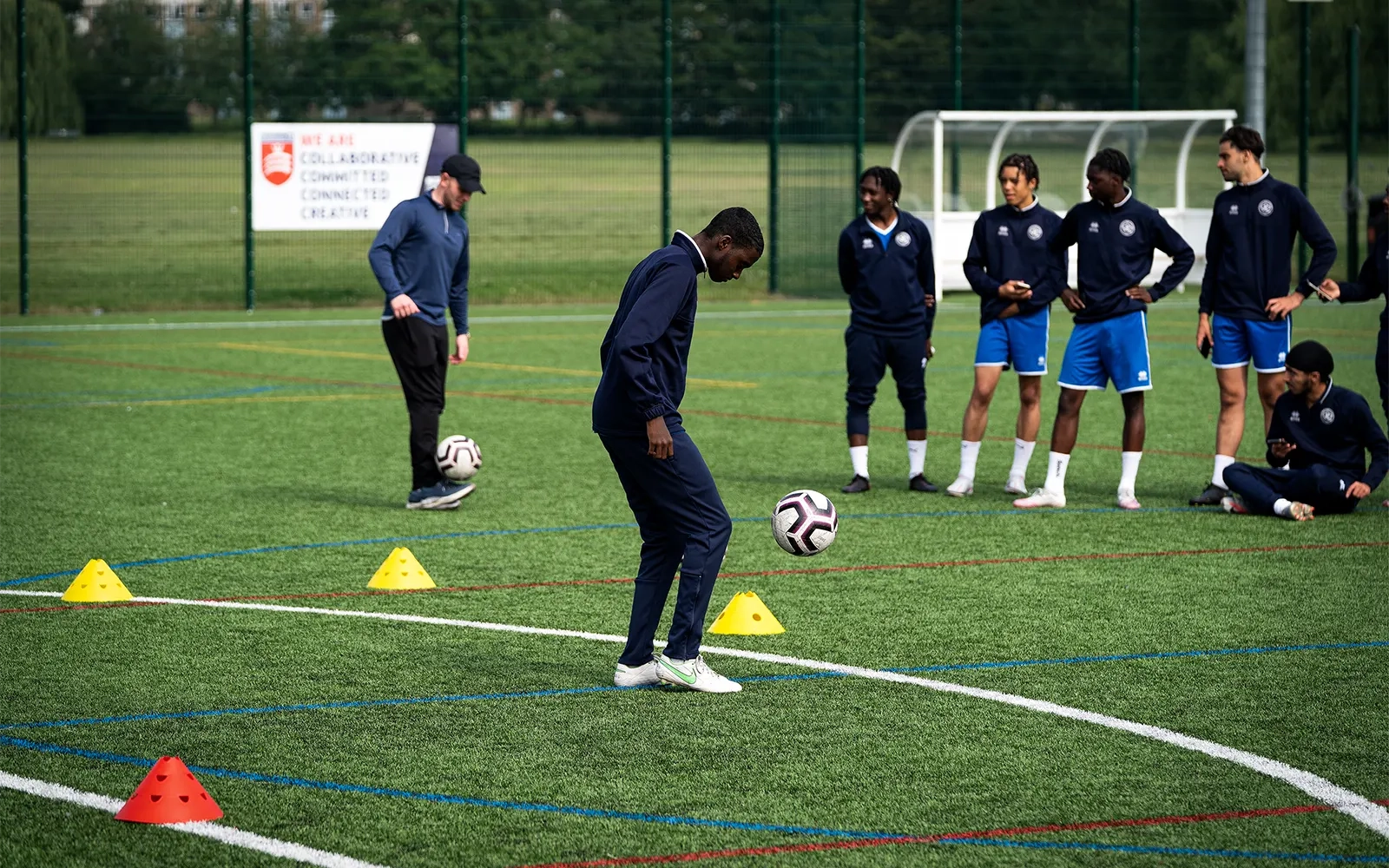 An action shot of a teenage boy during a football training session at a football pitch