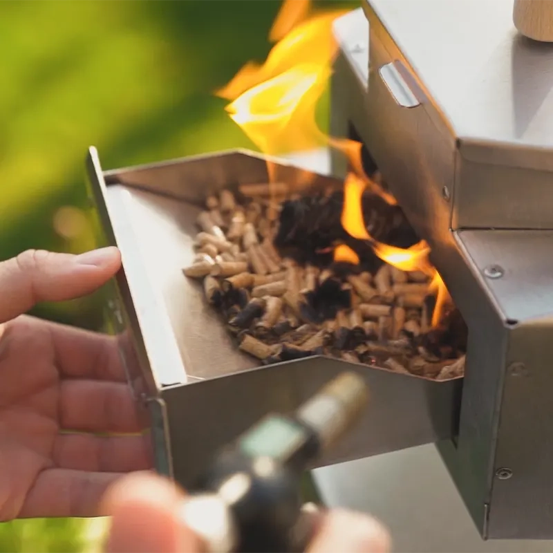 A close-up of a pizza oven being lit in a garden
