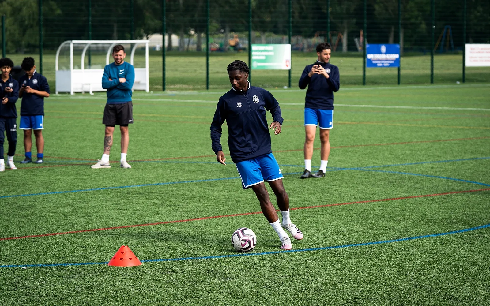 An action shot of a teenage boy during a football training session at a football pitch