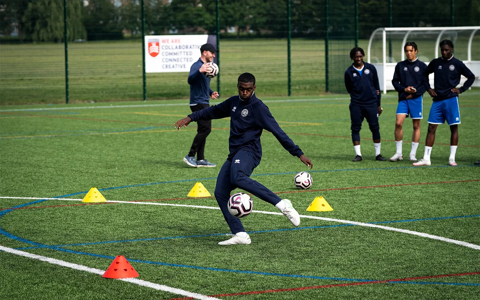 An action shot of a teenage boy during a football training session at a football pitch