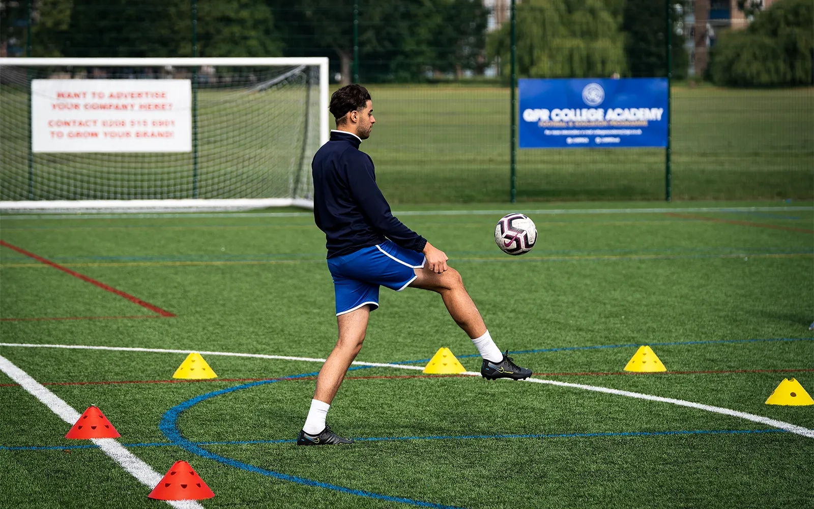 An action shot of a teenage boy during a football training session at a football pitch